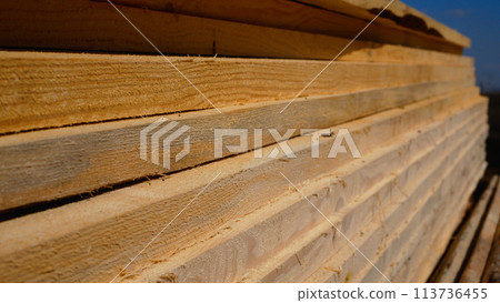 Many wooden planks lie on the ground in the open air. Building materials. 113736455