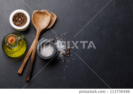 Spices, olive oil, and utensils on cooking table 113736486