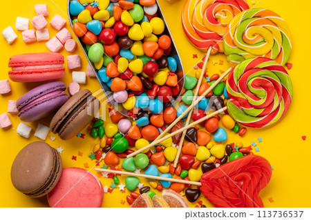 Various colorful candies, lollipops, and macaroons 113736537