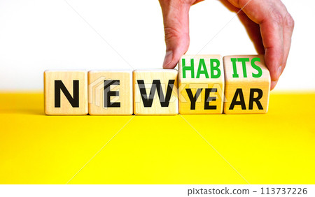 New year and habits symbol. Concept word New year New habits on wooden cubes. Beautiful yellow table white background. Psychologist hand. Psychological new year and habits concept. Copy space. New year and habits symbol. Concept word New year New habits on wooden cubes. Beautiful yellow table white background. Psychologist hand. Psychological new year and habits concept. Copy space. 113737226