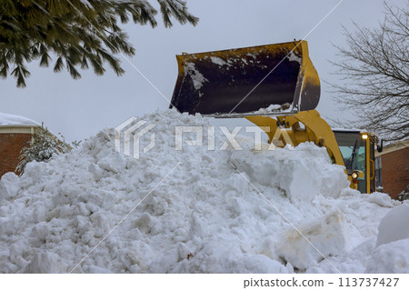 Snow is removed from parking lot by a snowplow truck following heavy snowfall Snow is removed from parking lot by a snowplow truck following heavy snowfall 113737427