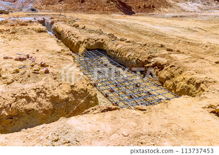 Earthworks, digging earthen trench dug for foundations to pouring a concrete Earthworks, digging earthen trench dug for foundations to pouring a concrete 113737453