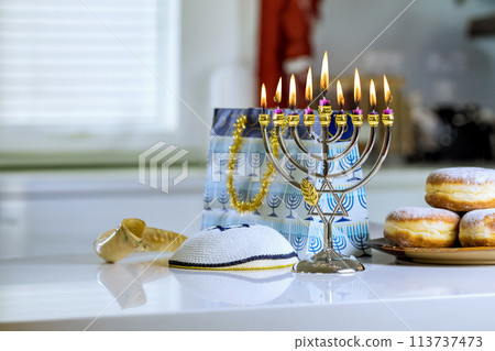 During Hanukkah Jewish religion holiday celebration, a Menorah candlelights 113737473
