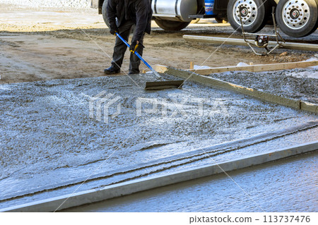 During construction of a new house driveway, wet cement has been poured concrete 113737476