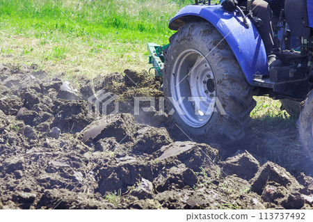 A tractor ploughs land in autumn in preparation for spring planting farming A tractor ploughs land in autumn in preparation for spring planting farming 113737492