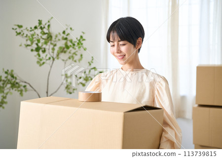 Woman carrying cardboard boxes 113739815