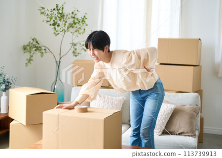 A woman hurts her back while moving A woman hurts her back while moving 113739913