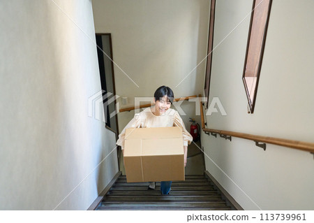 Woman carrying cardboard boxes Woman carrying cardboard boxes 113739961