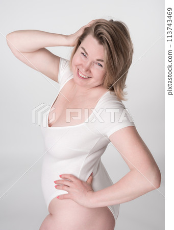 Mature adult woman looks so happy and confident in bodysuit, with one hand behind head and other on her hip. Concept of all about body positivity and embracing all shapes and sizes. High angle shot 113743469