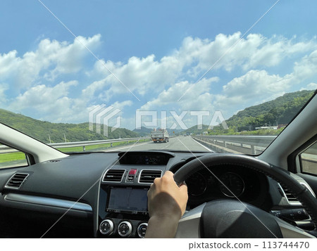 行駛在藍天和山地自然環繞的鄉村道路上 113744470