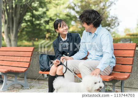 愛狗人士的父母、女兒和父親坐在公園的長凳上遛狗 愛狗人士的父母、女兒和父親坐在公園的長凳上遛狗 113744703