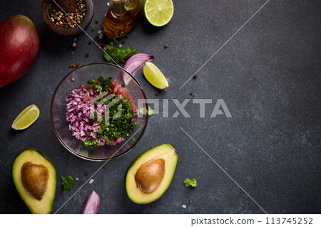 cooking traditional tuna tartare - chopped tuna, cilantro and onion in a glass bowl cooking traditional tuna tartare - chopped tuna, cilantro and onion in a glass bowl 113745252