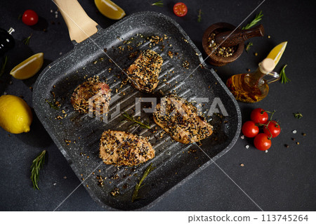 pieces of Organic Tuna fillet covered with sesame seeds frying on a hot grill pan 113745264