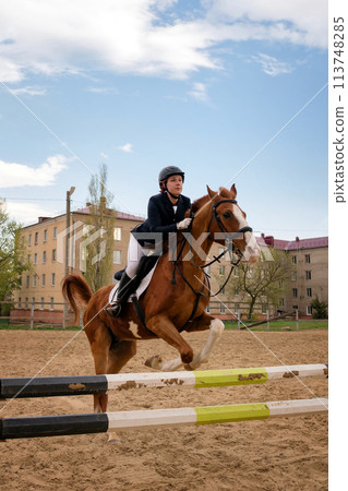 Rider jumping horse over obstacle, equestrian sport. Rider jumping horse over obstacle, equestrian sport. 113748285