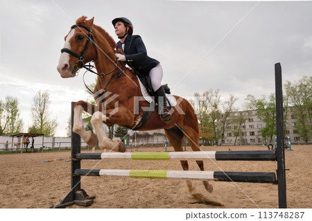 Horse and rider over jump, dynamic equestrian event Horse and rider over jump, dynamic equestrian event 113748287