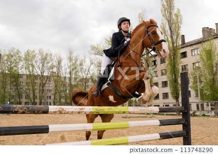 Front view of horse and rider executing jump. Front view of horse and rider executing jump. 113748290