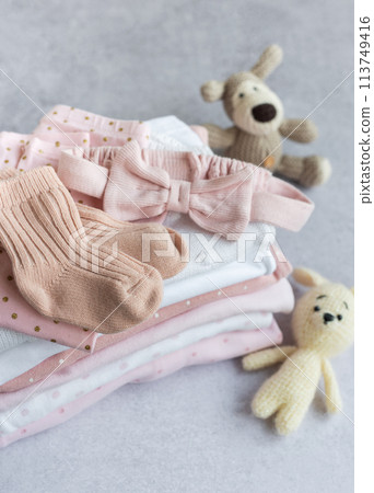 Stack of Baby bodysuits  on a grey background. 113749416