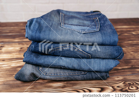 Stack of Jeans on Wooden Table Stack of Jeans on Wooden Table 113750201