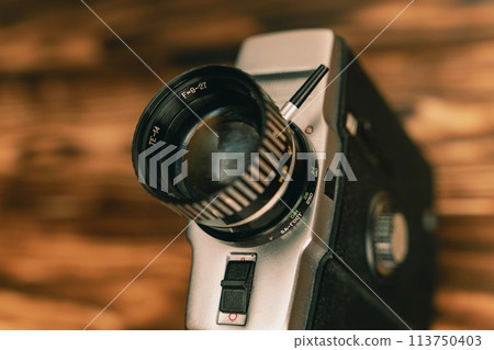 A close-up of a vintage movie camera shooting on 8 mm film from the 80s. A close-up of a vintage movie camera shooting on 8 mm film from the 80s. 113750403