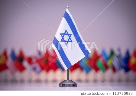 a small flag Israel with a star of david on it is sitting in front of a row of flags 113750983