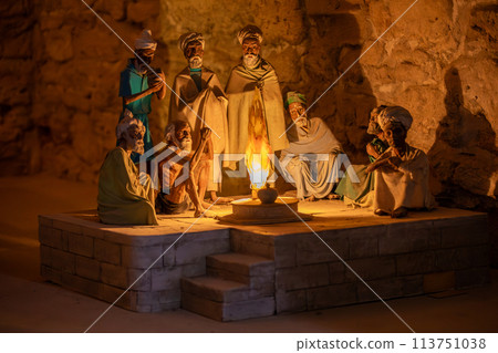 People gathered around a fire in a cave, discussing history, art, and mythology People gathered around a fire in a cave, discussing history, art, and mythology 113751038