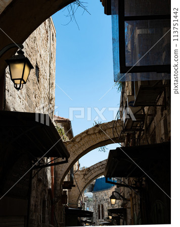 A narrow street among stone houses in old Jerusalem, Israel. A narrow street among stone houses in old Jerusalem, Israel. 113751442