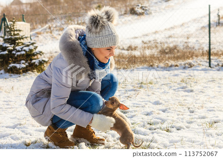 Woman playing with dog during winter Woman playing with dog during winter 113752067