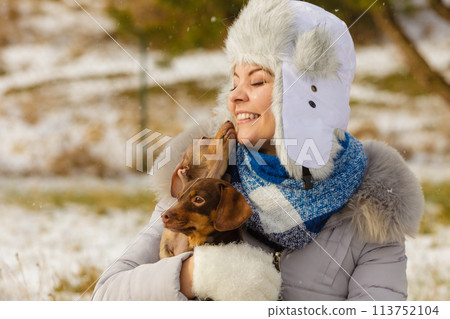 Woman playing with dogs during winter Woman playing with dogs during winter 113752104