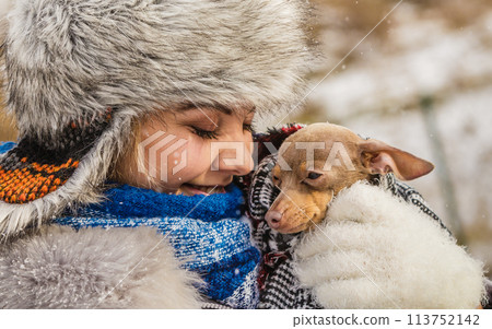 Woman hug warming her little dog in winter 113752142