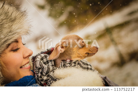 Woman hug warming her little dog in winter 113752217