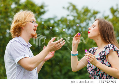Couple blowing soap bubbles, having fun 113752705