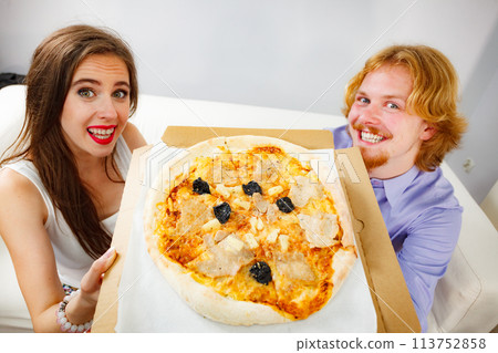 Funny couple eating pizza 113752858