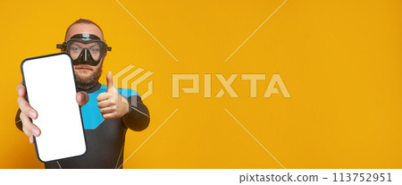 Scuba diver diving man holding smartphone with empty white screen display Scuba diver diving man holding smartphone with empty white screen display 113752951