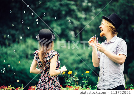Couple blowing bubbles outdoor Couple blowing bubbles outdoor 113752991