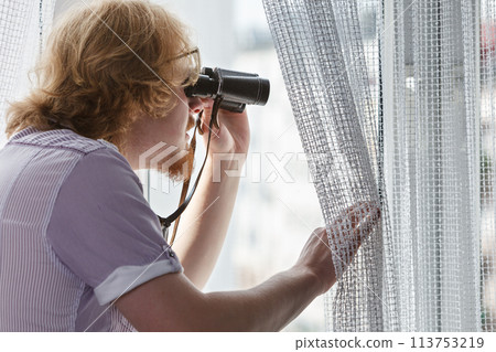 Man with binoculars spying on neighbors Man with binoculars spying on neighbors 113753219