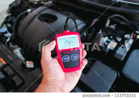 OBD2 or OBD scanner in a auto mechanic hand for engine system analysis OBD2 or OBD scanner in a auto mechanic hand for engine system analysis 113753253