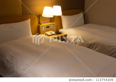Twin room bed in city hotel at night 113754209