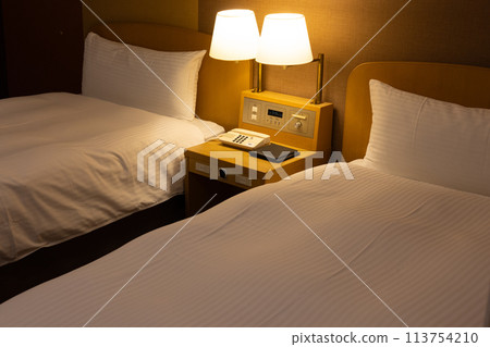 Twin room bed in city hotel at night 113754210