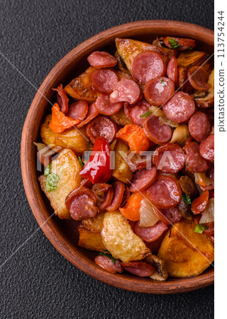 Grilled potatoes cut into slices with hunting sausages with garlic, onion Grilled potatoes cut into slices with hunting sausages with garlic, onion 113754244