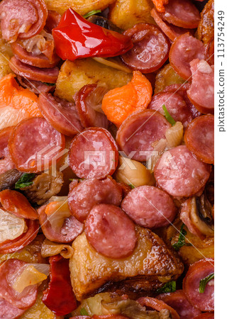 Grilled potatoes cut into slices with hunting sausages with garlic, onion Grilled potatoes cut into slices with hunting sausages with garlic, onion 113754249