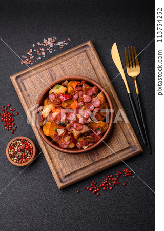 Grilled potatoes cut into slices with hunting sausages with garlic, onion Grilled potatoes cut into slices with hunting sausages with garlic, onion 113754252
