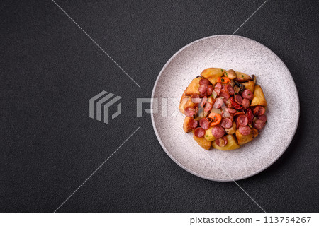 Grilled potatoes cut into slices with hunting sausages with garlic, onion 113754267