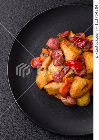 Grilled potatoes cut into slices with hunting sausages with garlic, onion Grilled potatoes cut into slices with hunting sausages with garlic, onion 113754284