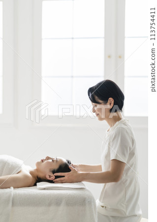 接受頭部按摩和治療師的年輕女性乾頭水療美容院形象 113754411