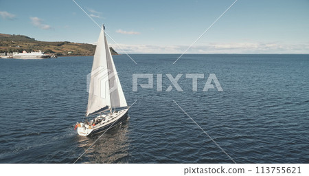 Closeup slow motion of sail boat at ocean gulf aerial. Racing yacht at sea bay. Majestic seascape at luxury sailboat at Brodick pier, Arran island shore, Scotland, Europe. Cinematic summer cruise Closeup slow motion of sail boat at ocean gulf aerial. Racing yacht at sea bay. Majestic seascape at luxury sailboat at Brodick pier, Arran island shore, Scotland, Europe. Cinematic summer cruise 113755621