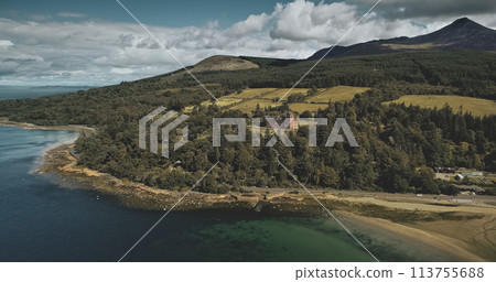 Scotland Arran island landscape aerial zooming view: forests, meadows, mountains at summer day. Clouds on skyline near Goat Fell peak. Epic scene of Atlantic coastline. Cinematic shot 113755688