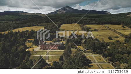 Scotland landscape aerial shot: mountains, ancient Brodick Castle with Goatfell mount. Epic scenery of Scottish landmarks. Wonderful forests and valleys at summer day wide view 113755689