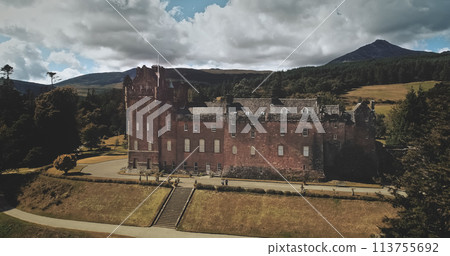 Scotland Brodick Castle aerial front shot: heritage of Scottish. Historical landmark of Arran Island with majestic landscape. Parks and garden near building under cloudy sky. Scenery view 113755692