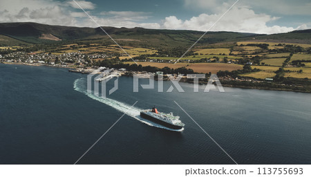Scotland, Brodick Ferry Terminus aerial panoramic shot of ship crossing, Arran Island. Beautiful passenger ferry go from harbor at Firth-of-Clyde Gulf to mainland. Cinematic scenery view 113755693