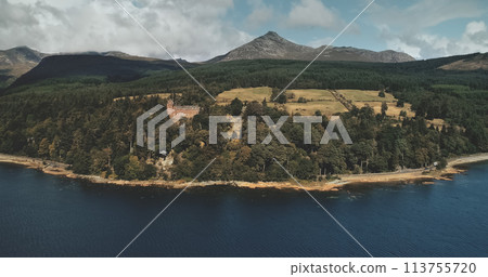 Scotland, Brodick ocean bay aerial view: alone sailboat at Firth-of-Clyde Gulf water against Scottish nature landscape. Beautiful mountains at horizon with wide woods. Panorama scenery shot Scotland, Brodick ocean bay aerial view: alone sailboat at Firth-of-Clyde Gulf water against Scottish nature landscape. Beautiful mountains at horizon with wide woods. Panorama scenery shot 113755720
